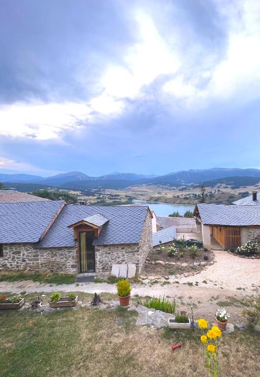 un groupe de bâtiments avec des fleurs dans une cour dans l'établissement La bergerie cosy avec vue sur lac et montagnes, à Réal