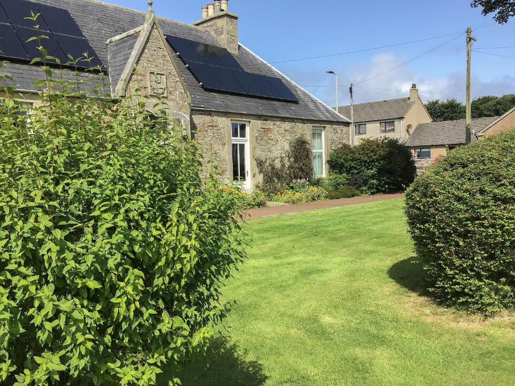a house with solar panels on the roof at Gladstone Cottage in Castletown