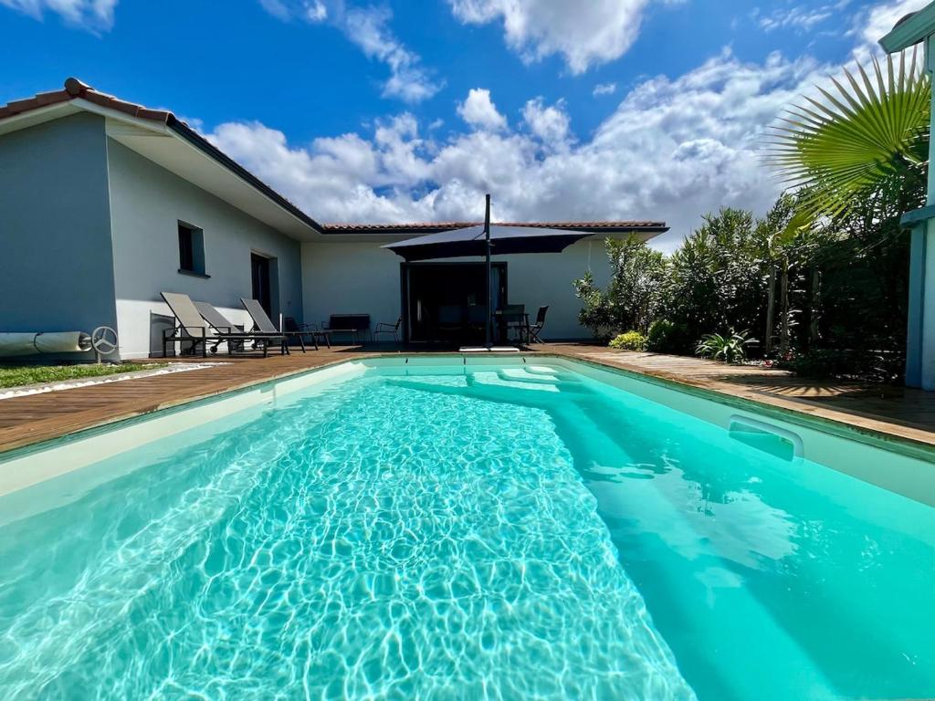 une piscine devant une maison dans l'établissement Villa La Pignotte 2 min de la plage, à Gujan-Mestras