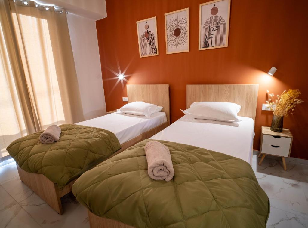 two beds in a hotel room with towels on them at Gemini in Laganas