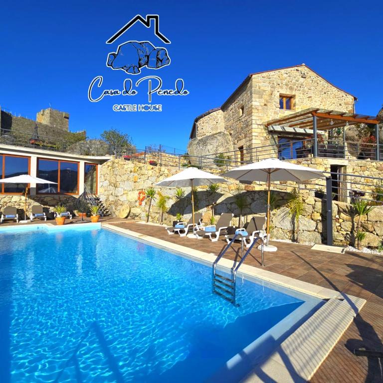 a swimming pool in front of a villa at Casa do Penedo Castle House in Linhares