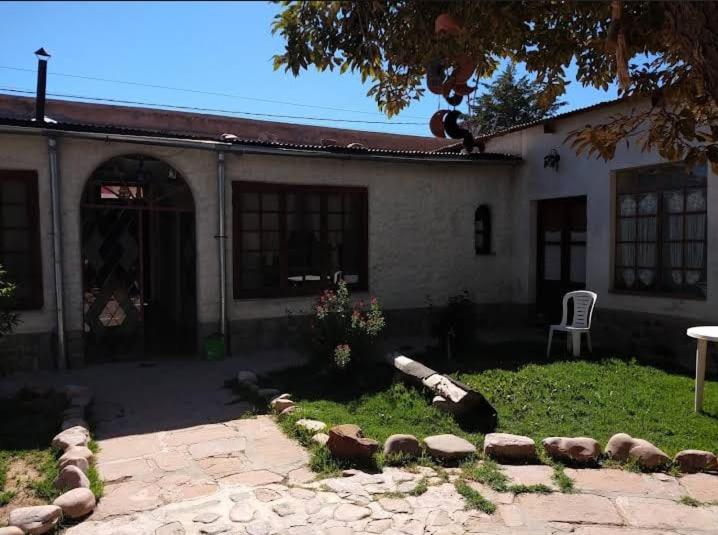 a house with a patio and a chair in the yard at La Maison Enchantee in Humahuaca