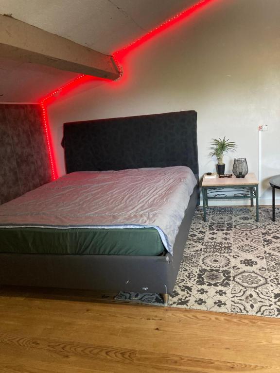 una camera da letto con un letto con una luce rossa sopra di Maison pour 6 personnes avec jardin et piscine ad Artigues-près-Bordeaux
