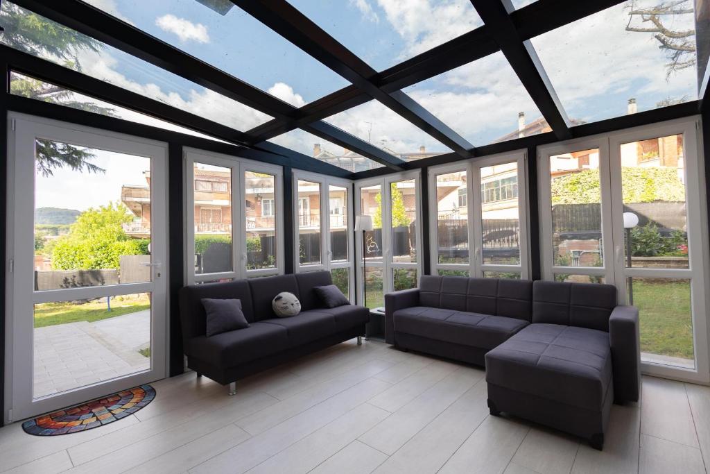 a living room with couches and windows at House Of Cat in Grottaferrata