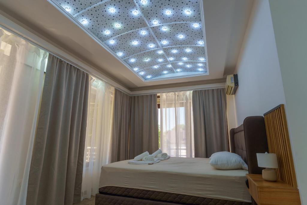 a bedroom with a bed with a ceiling with lights at Motel Aqua Kozarac in Kozarac
