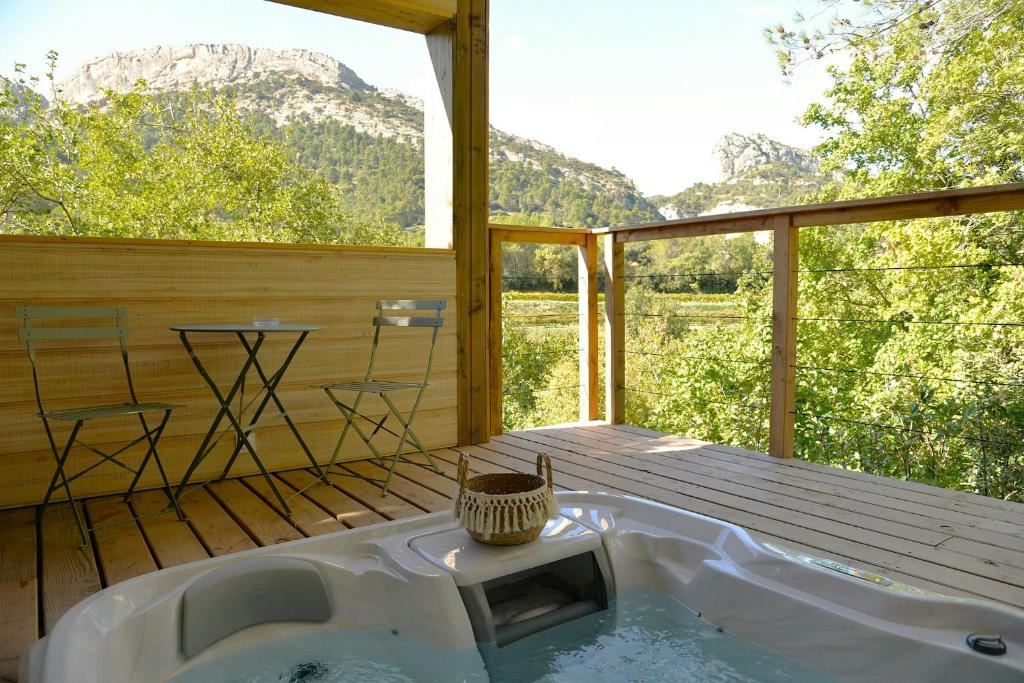 Cette chambre dispose d'une baignoire et offre une vue sur les montagnes. dans l'établissement Treehouse Lodge In The Dentelles De Montmirail, à Lafare