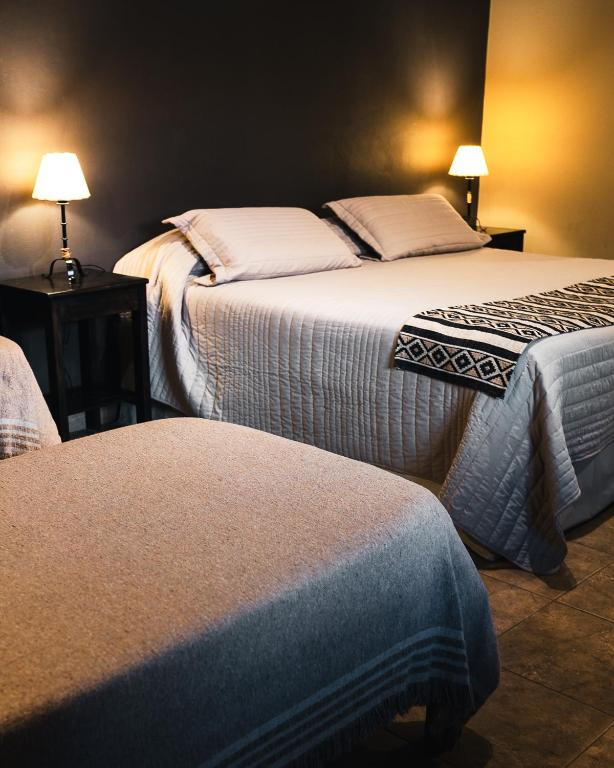 two beds in a hotel room with two beds at Casagrande Hotel de Adobe in Tinogasta