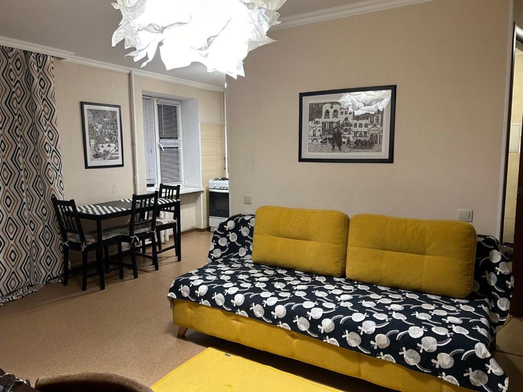 een woonkamer met een bank en een tafel bij Apartment on Knyahyni Ol'hy Street in Rivne