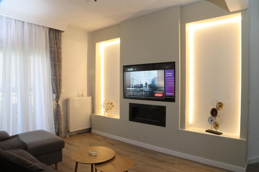 a living room with a flat screen tv on a wall at Meraki Living in Néa Michanióna