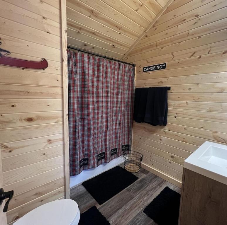 a bathroom with a shower in a wooden cabin at Dragonfly Nest, cabin vibe, river views in Fountain City