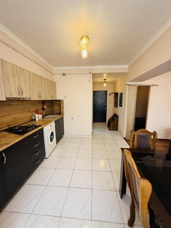 a large kitchen with a stove and a microwave at Квартира in Aghk'ilisa