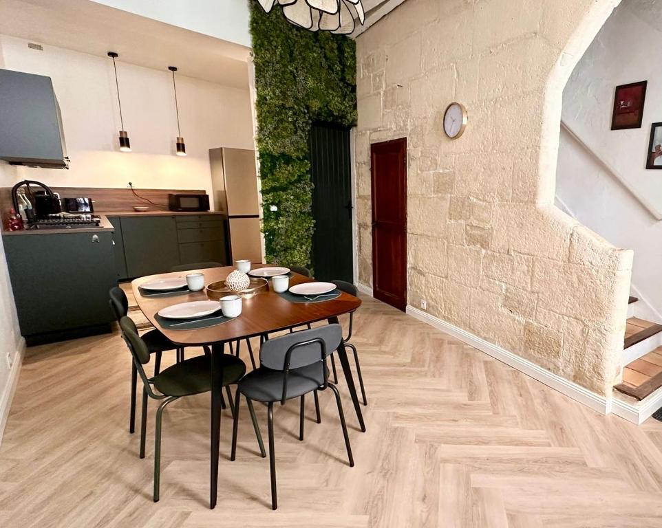 une cuisine et une salle à manger avec une table et des chaises dans l'établissement Maison rénovée avec Clim et loggia - arles centre, à Arles
