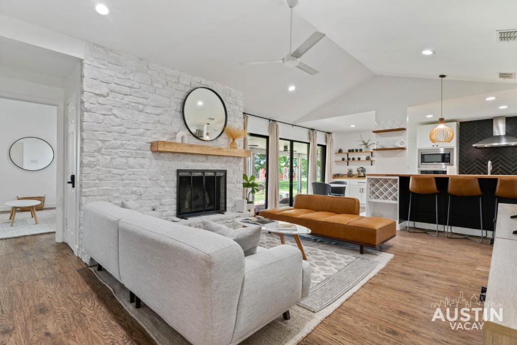a living room with a couch and a fireplace at Backyard w Deck, Yoga Space 3BR 2BA Home Parking Near Domain by Austin Vacay in Austin