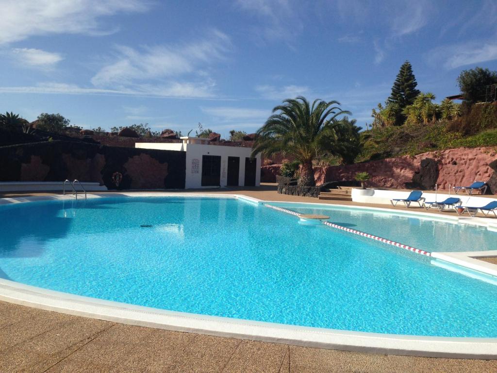 een groot zwembad met blauw water bij Villa Las Coloradas 15 in Playa Blanca