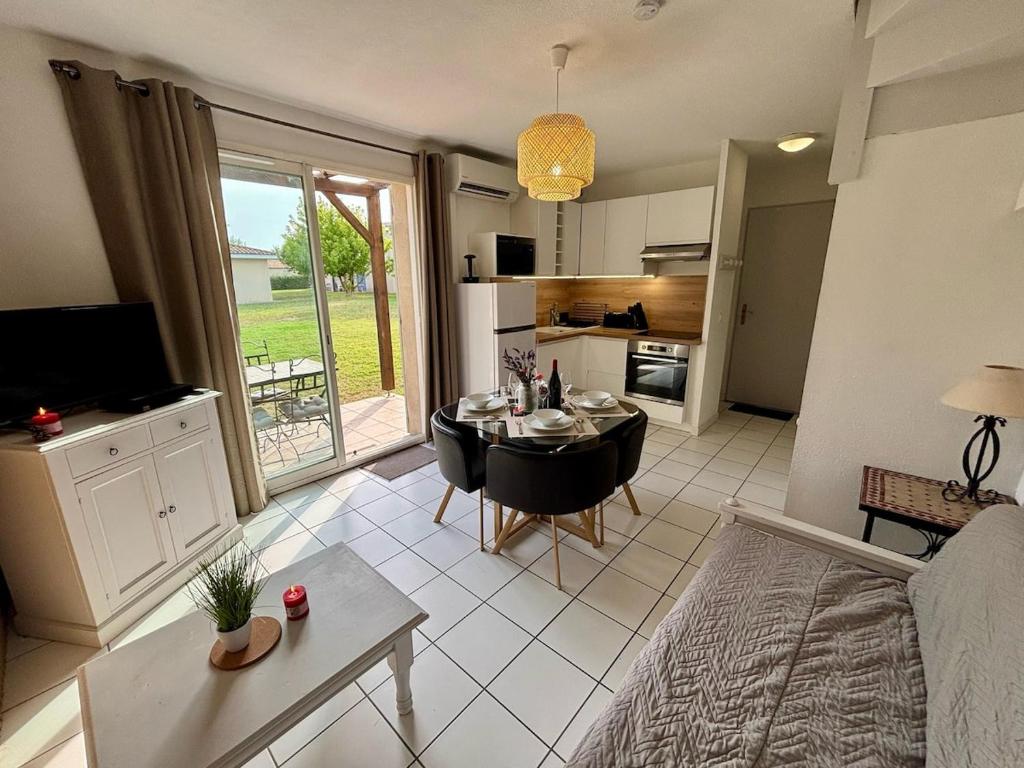 Il comprend un salon avec une table à manger et une cuisine. dans l'établissement Douceur de vivre en Provence, à Saint-Saturnin-lès-Avignon