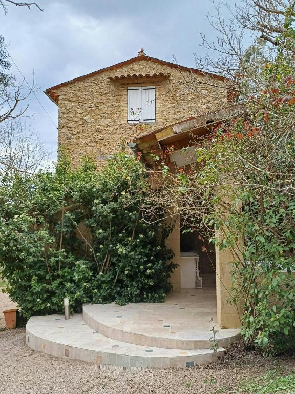 une maison en briques avec une fenêtre au-dessus dans l'établissement Provençal Mas In Fayence, à Fayence
