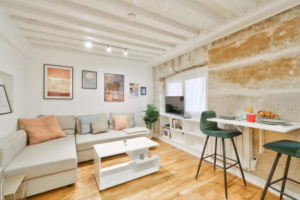 un salon avec un canapé et une table dans l'établissement Modern Parisian Retreat Cozy T2 in Paris 02, à Paris