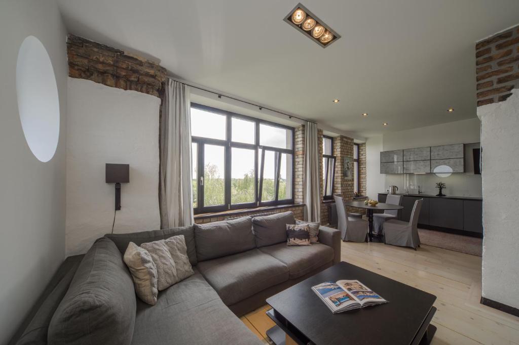 una sala de estar con un sofá y una mesa en Riga Luxury Loft with Terrace, en Riga