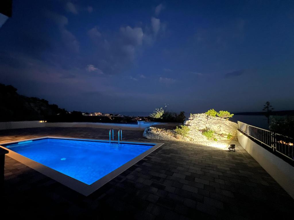 a swimming pool at night with a view at Apartman Magic View in Baška Voda