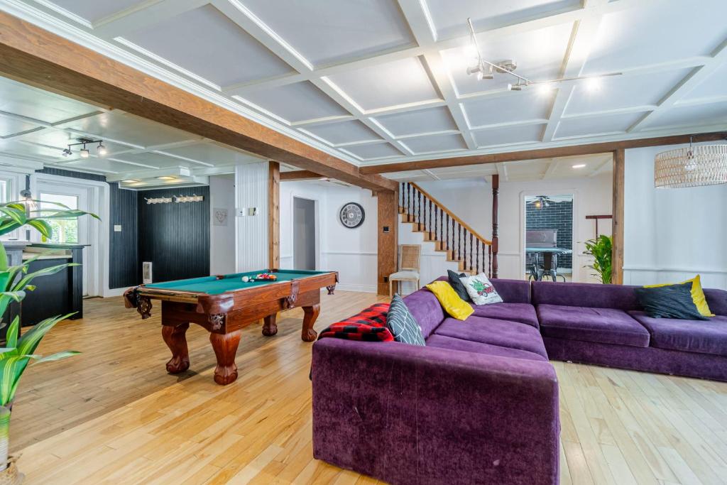 a living room with a pool table and purple couches at Old-Time Charm - 12 Guests - Billiards & Hot Tub in Sainte-Anne-de-Beaupré