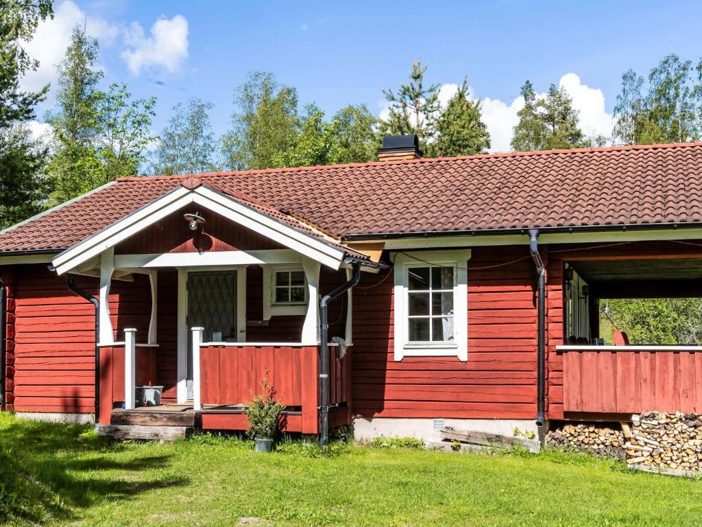 a red house with a red fence in a yard at 4 star holiday home in SÅGMYRA in Sågmyra