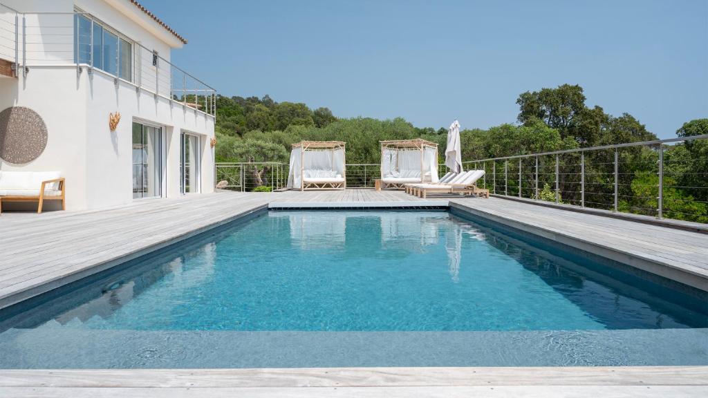- une piscine à côté d'une maison dans l'établissement Villa avec piscine et vue mer à 230m de la plage, à Zonza