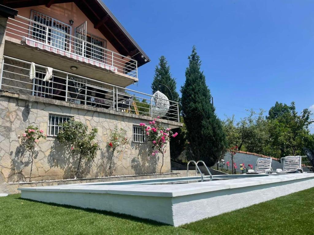 a swimming pool in front of a house at Vila sa bazenom Lily in Konjic