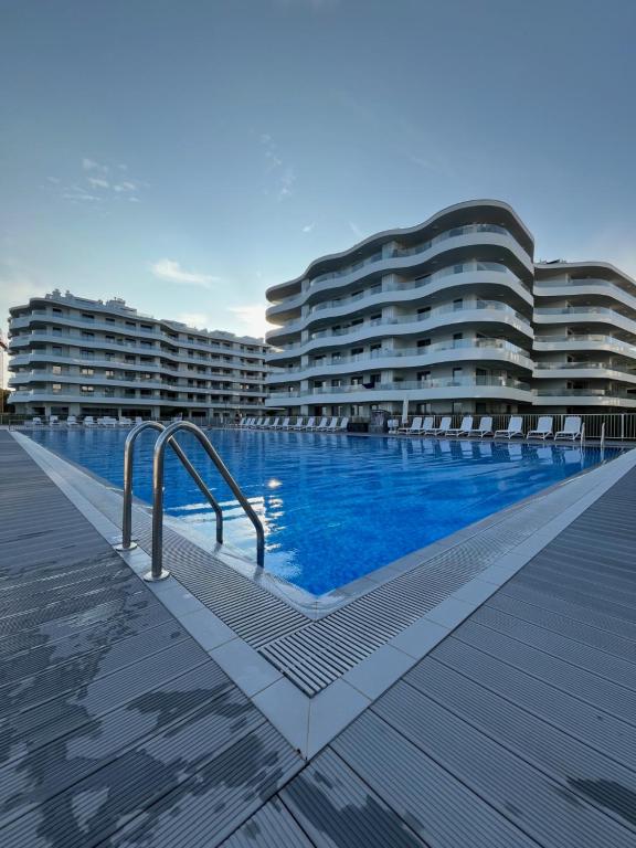 basen przed dwoma dużymi budynkami w obiekcie Sunrise Apartament w Rogowie