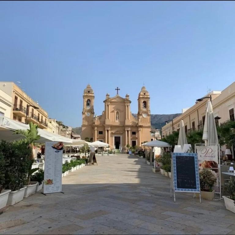 a building with a church in the middle of a street at Casa Monteserrato in Terrasini