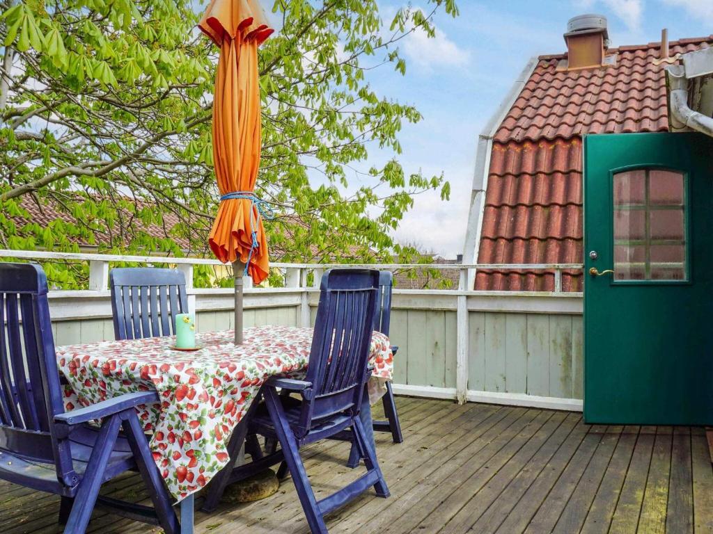 a table and chairs on a deck with an umbrella at 5 person holiday home in LYSEKIL in Lysekil
