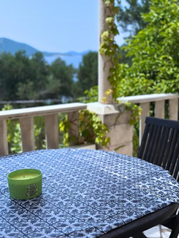 a green cup sitting on a table with a blue table cloth at Island house MARTA in Koločep