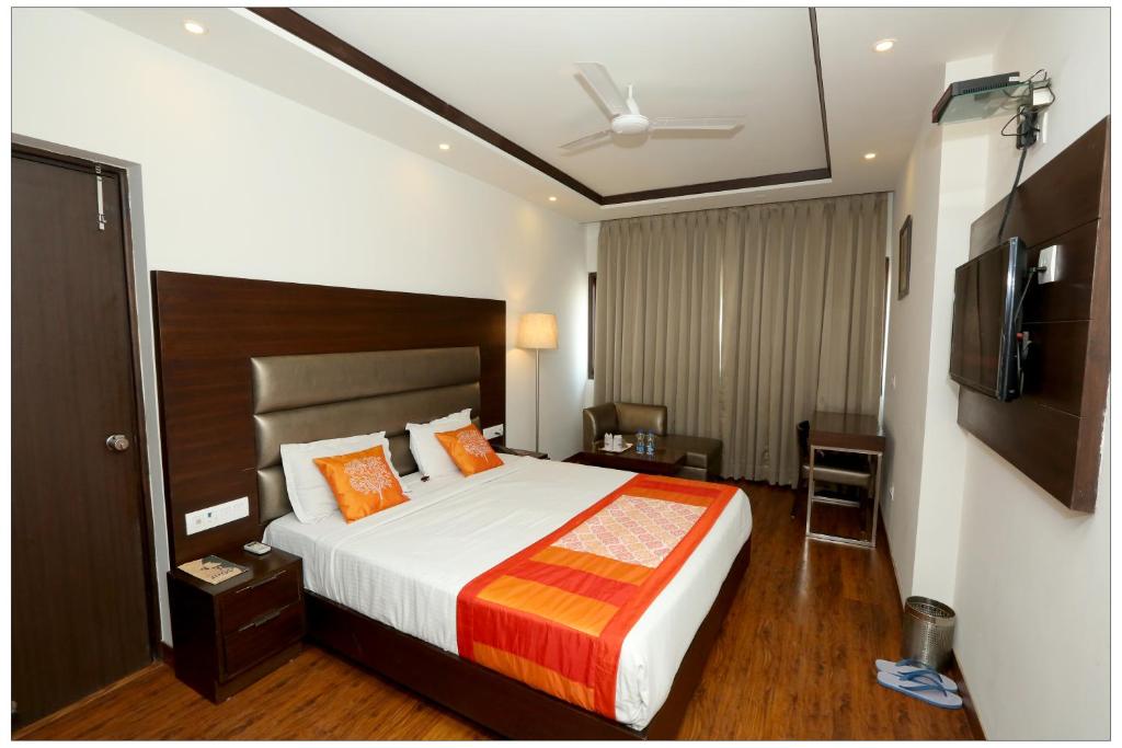 Habitación de hotel con cama y TV en Airport Hotel The R Blues - New Delhi, en Nueva Delhi