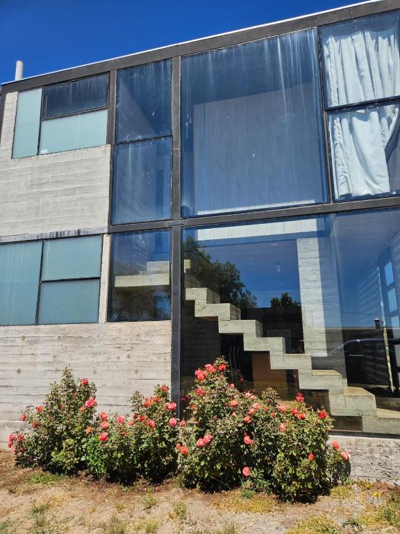 a building with stairs and flowers in front of it at Cabañas Litueche 1 in El Rosario