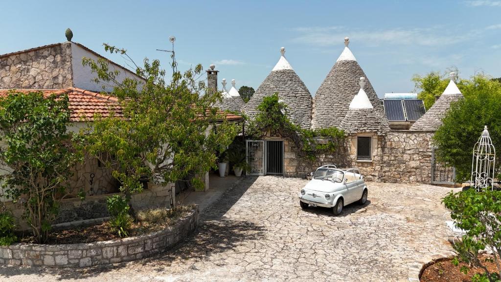 une voiture garée devant une maison dans l'établissement Trullo Alba, à Cisternino