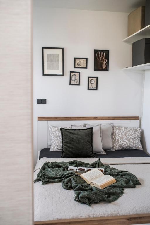 a bed with a blanket and a book on it at MFapartments in Vrbovec