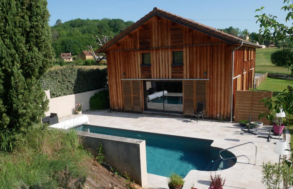 une maison avec piscine devant un immeuble dans l'établissement Le Séchoir de Saint Vincent, à Saint-Vincent-le-Paluel