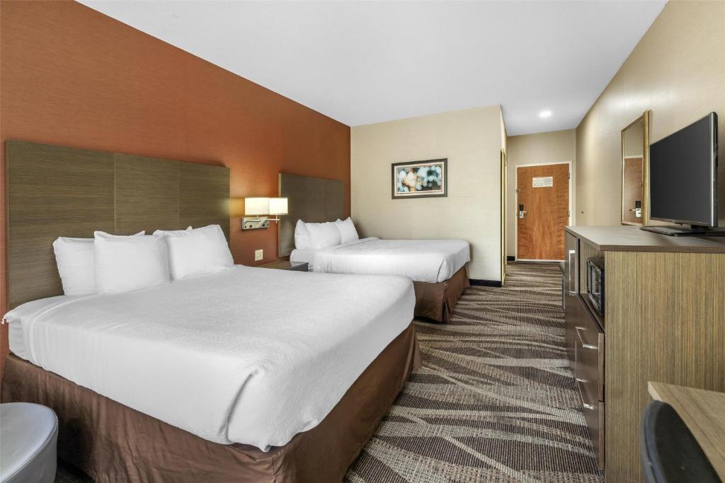 a hotel room with two beds and a flat screen tv at Best Western Plus University Inn, Olean NY in Olean
