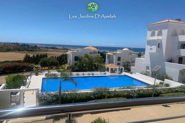 ein Schwimmbad vor einem Gebäude in der Unterkunft Les Jardins d'Assilah in Asilah