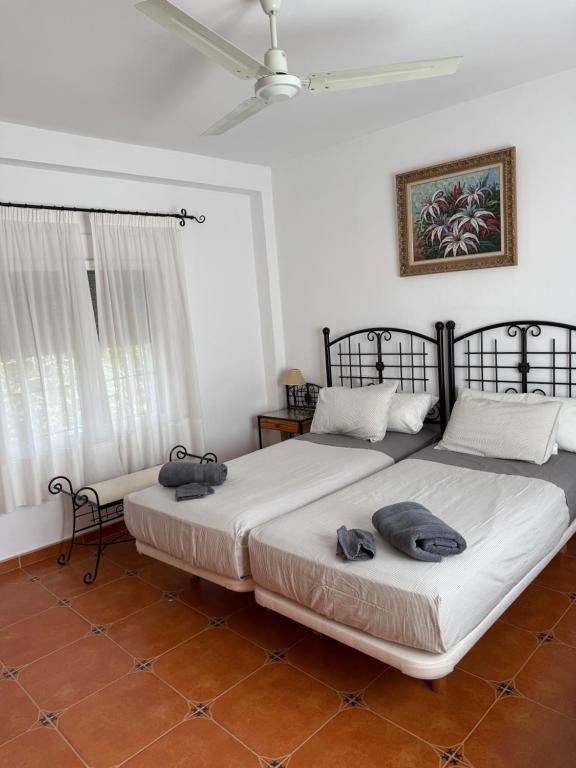 2 Betten in einem Zimmer mit weißen Wänden in der Unterkunft Finca Jaralta de Carmen in La Puebla de los Infantes