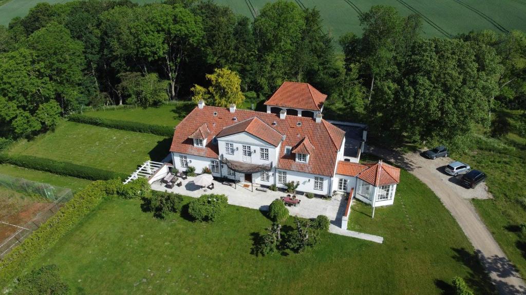 an aerial view of a large house on a green field at Historic House In Skjoldungernes Land Park in Kirke Såby