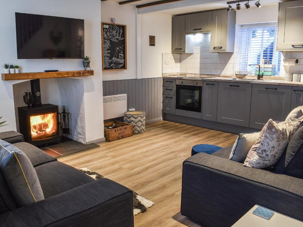 ein Wohnzimmer mit zwei Sofas und einem Kamin in der Unterkunft Low Quay Cottage in Conwy