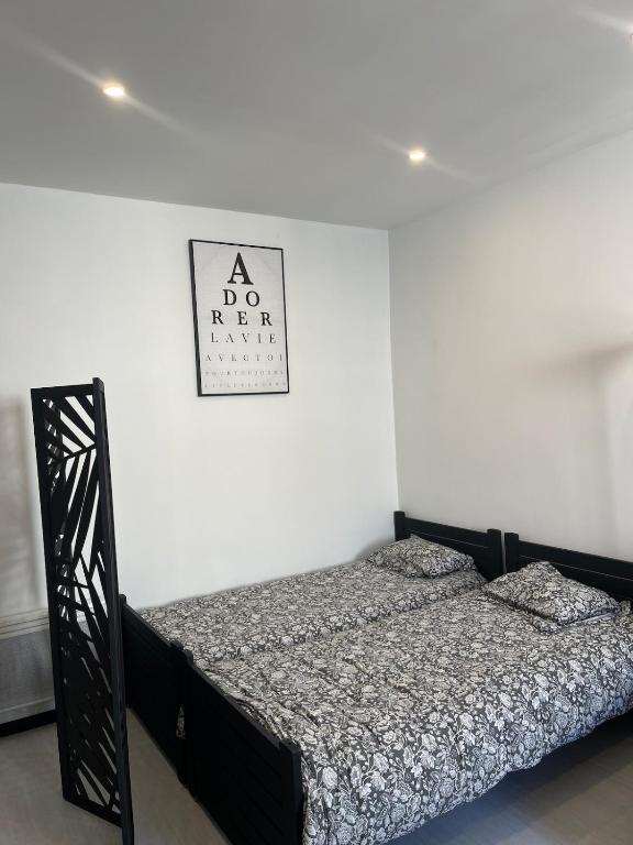 ein Bett in einem Schlafzimmer mit einem Schild an der Wand in der Unterkunft Azurian stay in Vallauris