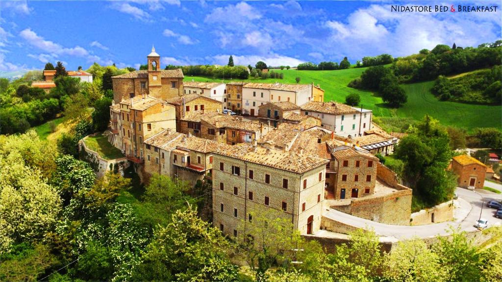 un grupo de edificios en la cima de una colina en Nidastore Holidays, en Arcevia