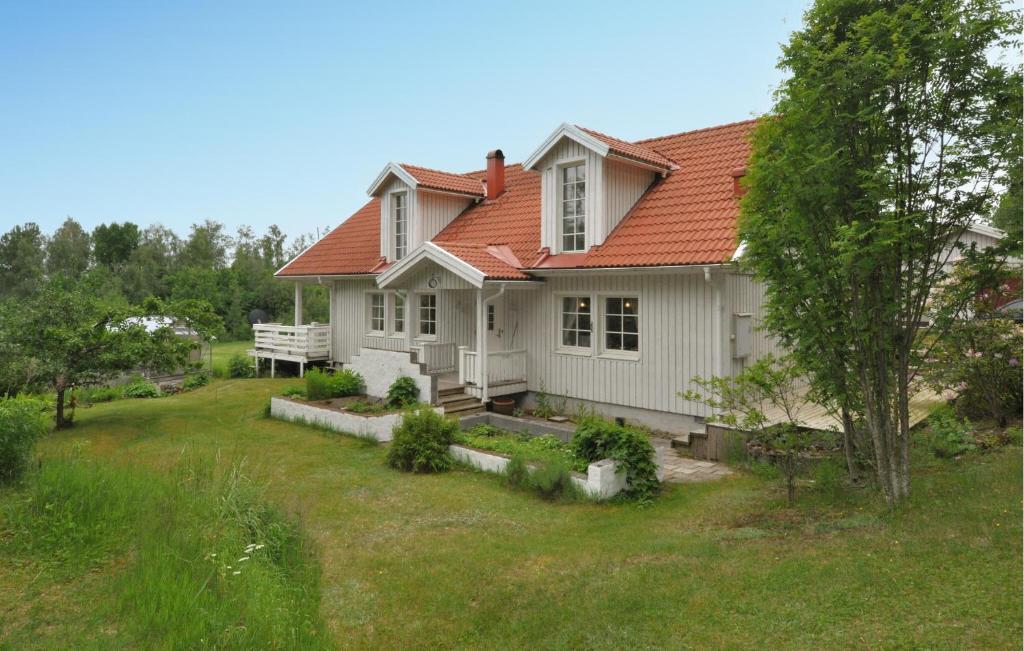 a white house with a red roof and a yard at Villa Utsikten in Kristinehamn