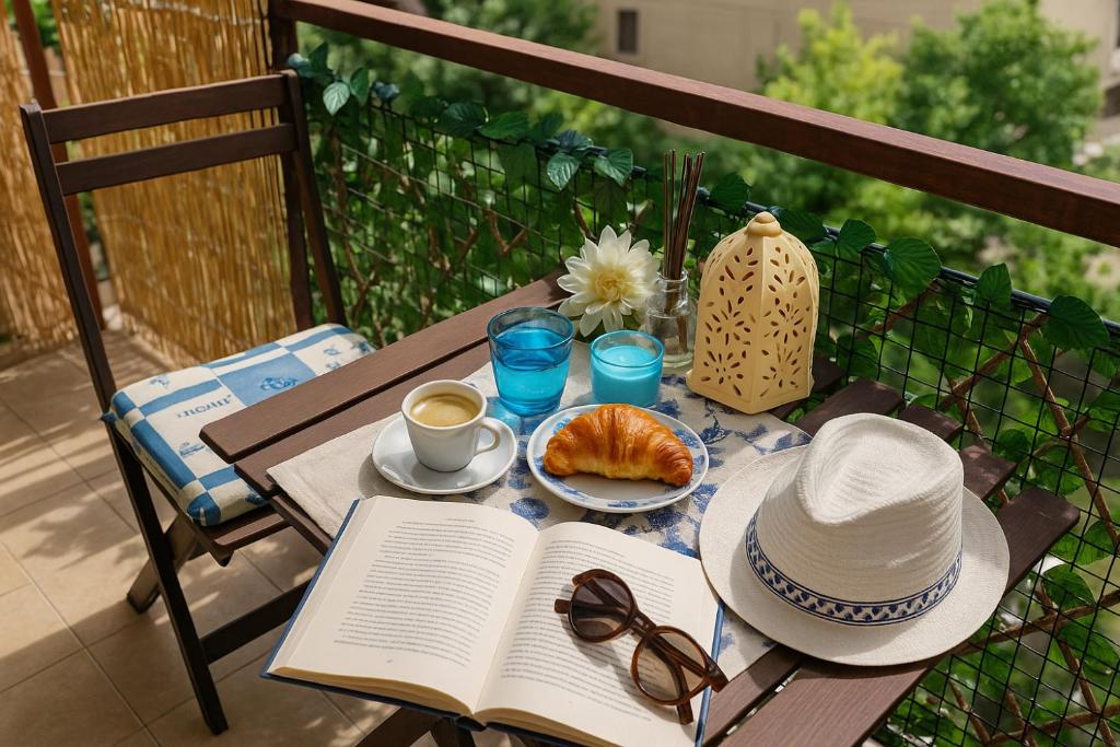 a table with a book and a hat and a cup of coffee at Blue apartment, Alghero, near beaches in Alghero