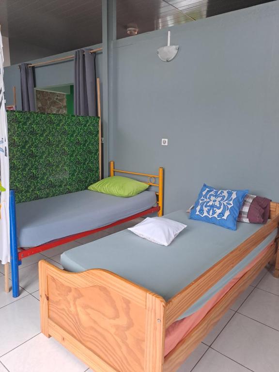 duas camas estão sentadas num quarto com em Fare de l'escale Em Faaa