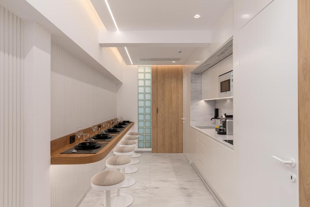 Un pasillo con una fila de taburetes en una cocina. en capital house, en Atenas