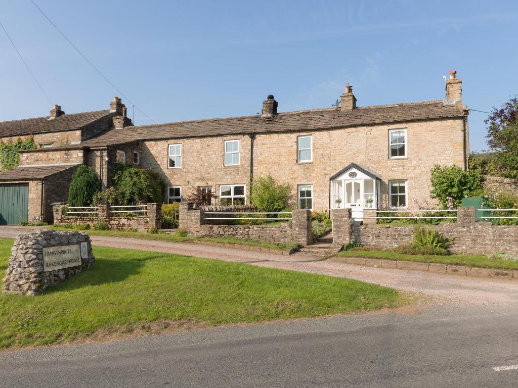 an old brick house with a road in front of it at Abraham's Cottage in Low Eskcleth
