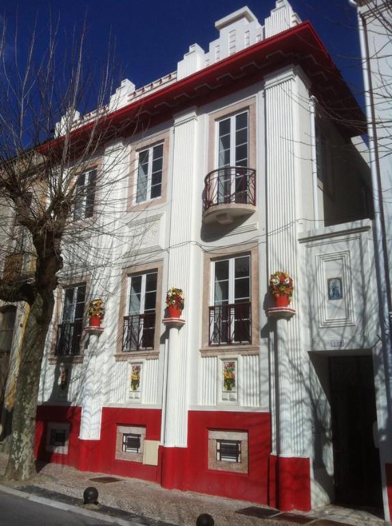 Edificio blanco y rojo con ventanas y balcones en Puzzle Suites B&B, en Figueira da Foz