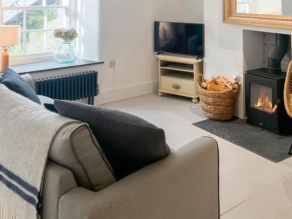 a living room with a couch and a fireplace at Cottage - Uk45985 in Mousehole